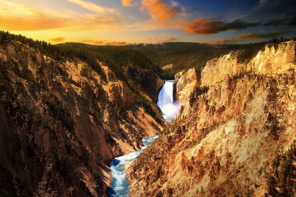 Hermoso cielo al atardecer. Cascada en las rocas de Yellowstone