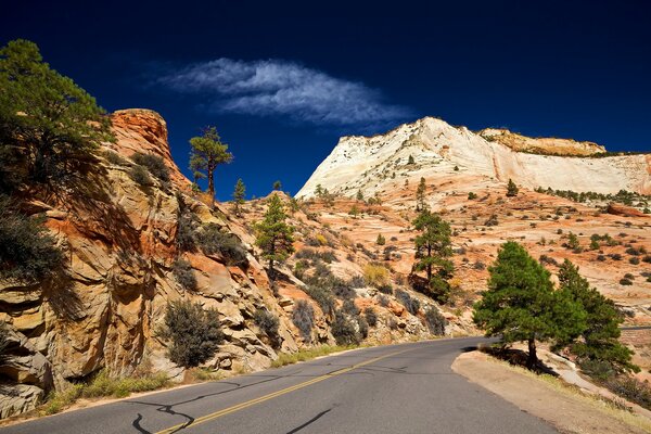 The road along the mountains. Blue sky