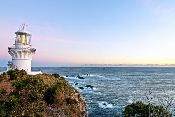 Phare au bord de la mer au lever du soleil