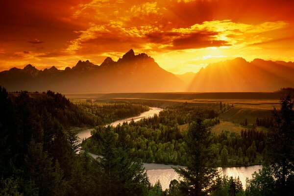 Feuriger Sonnenuntergang in den Bergen mit Blick auf den Fluss