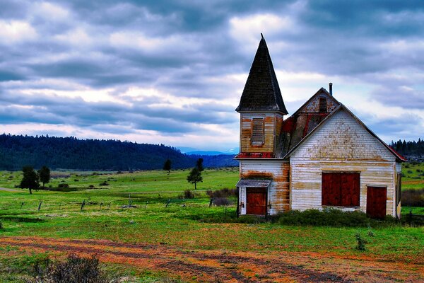 Maison dans un champ avec vue sur la forêt et les montagnes