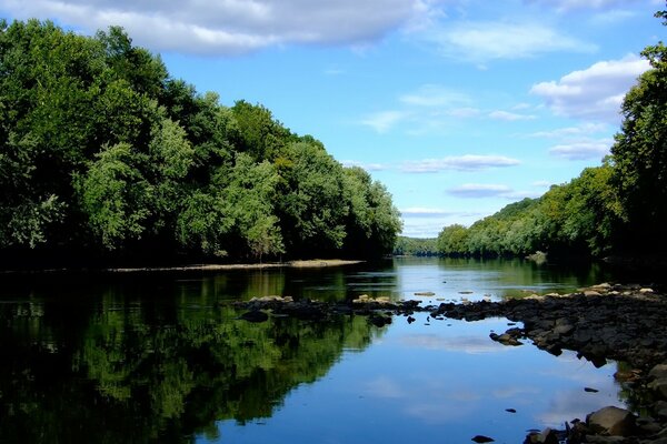 A calm river. Reflection of clouds in water