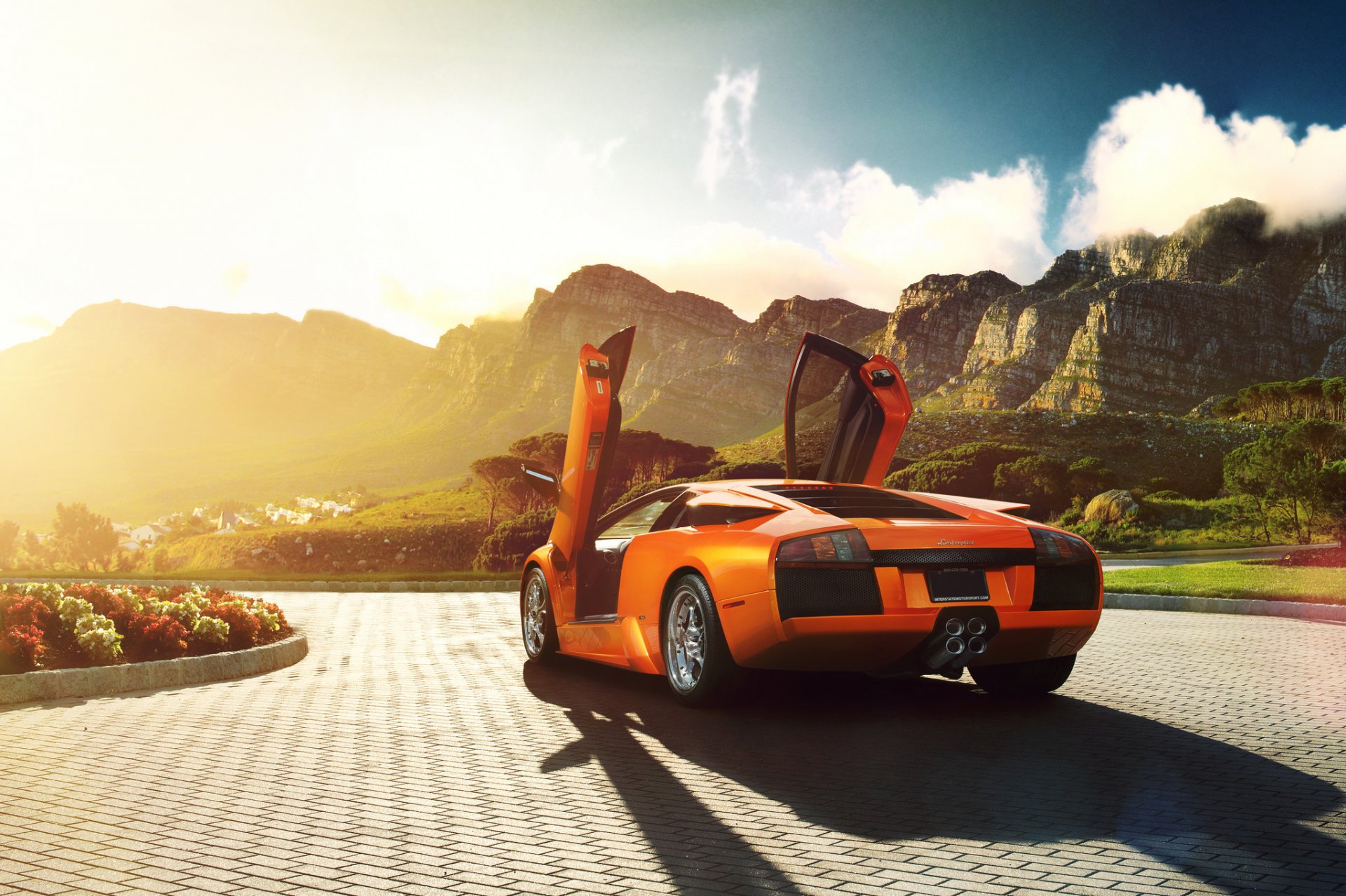 lamborghini murcielago v12 orange arrière ronaldo stewart lamborghini lamborghini murcelago portes ouvertes portes lambo fleurs pavés montagnes soleil éblouissement