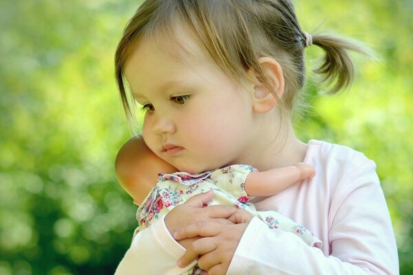 A little girl hugs her favorite doll