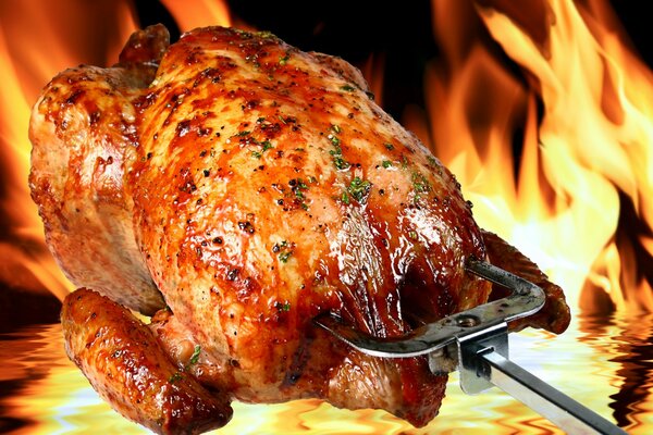 Poulet grillé avec une croûte sur fond de feu