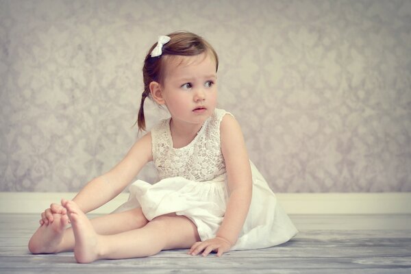 Young ballerina on the floor barefoot