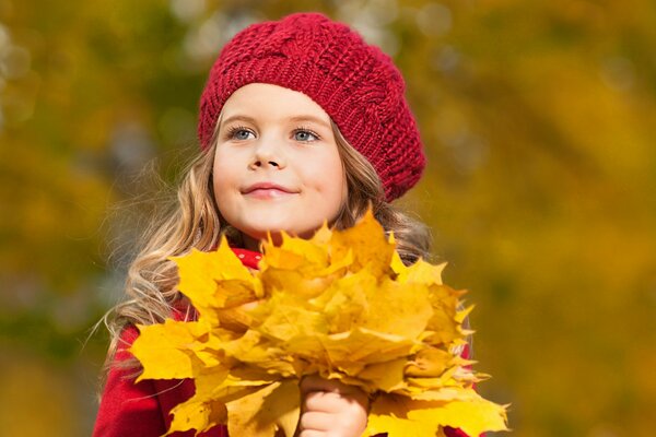 Ragazza in berretto rosso con bouquet autunnale