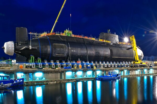 A nuclear submarine in a lighted night dock