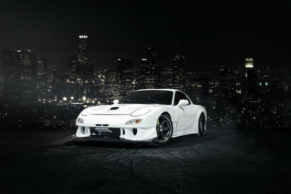 A white car in the semi-darkness on the highway