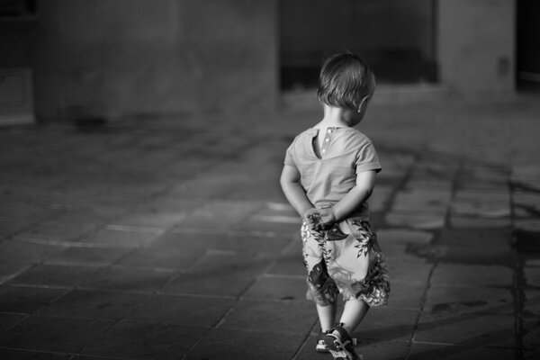 Black and white photo of a boy on the street