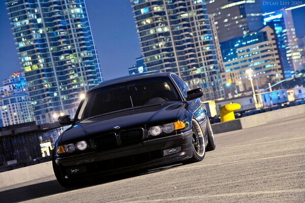 Black low BMW on the city stone square