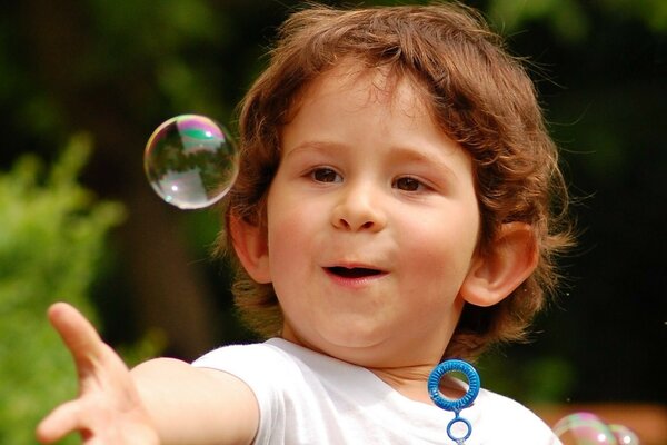 The child blows soap bubbles