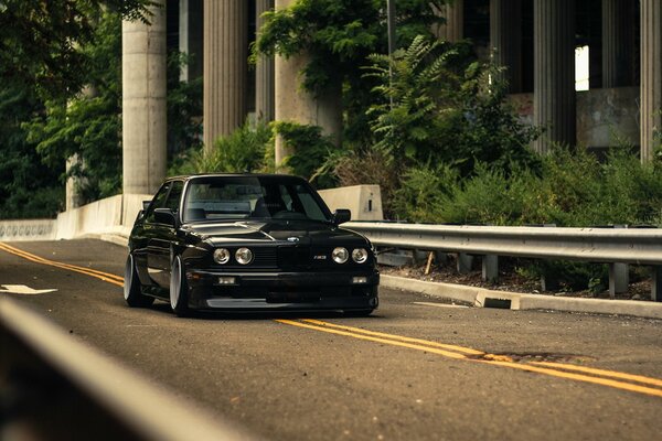 En la pista de un BMW negro con los faros apagados