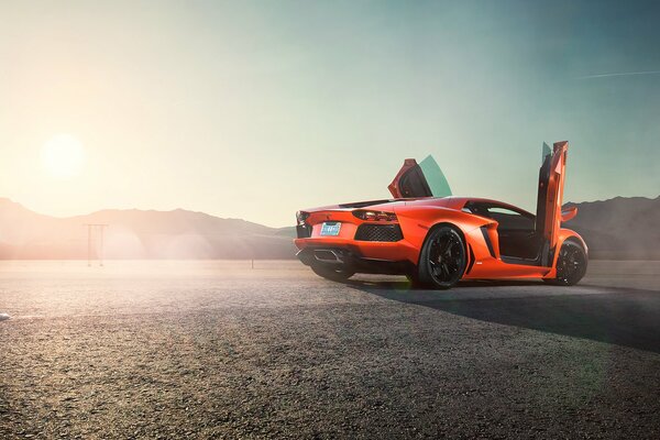 Orange lamborghini aventador lp 700-4 auf Sonnenaufgang hintergrund