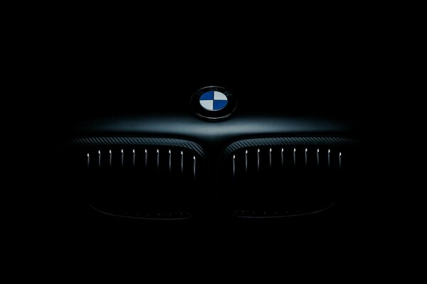 BMW-Symbol auf schwarzem Hintergrund. Kühlergrill im Dunkeln