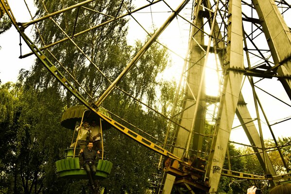 Ragazzo sulla ruota panoramica sullo sfondo degli alberi