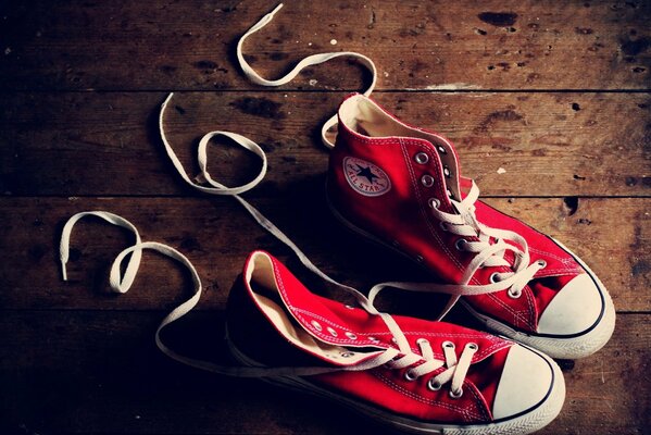 Sneakers rosse sul pavimento in legno