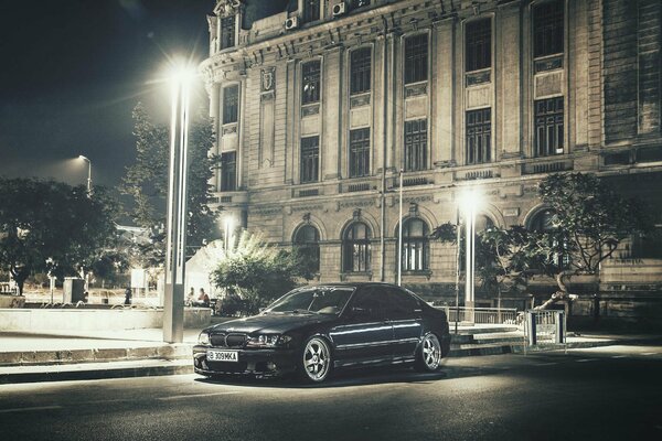 A car illuminated by the lights of the night city