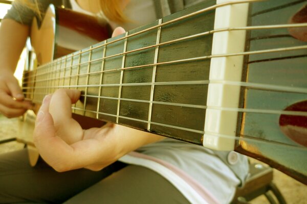 Tastiera della chitarra. Corde di chitarra. Chitarrista. Accordo. Ragazza con la chitarra