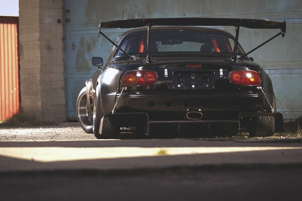 Une Mazda noire se tient dans le garage