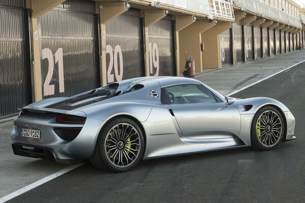 On the asphalt near the garage is a gray Porsche