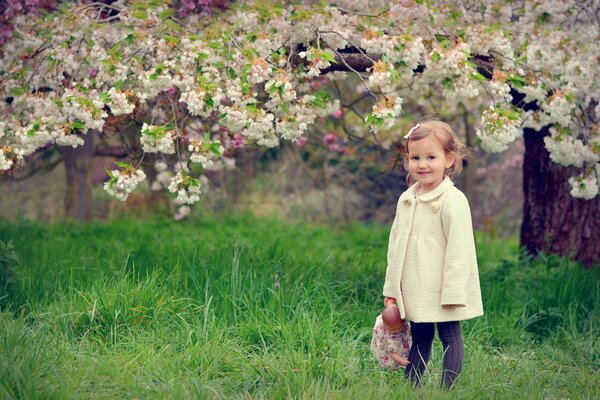 A joyful child is standing under a tree