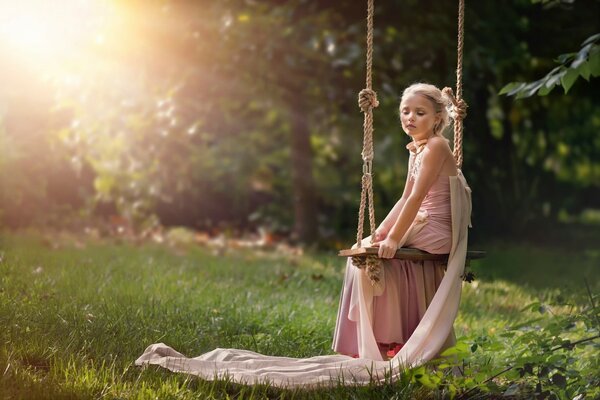 Fille dans la nature sur une balançoire avec une humeur mystérieuse