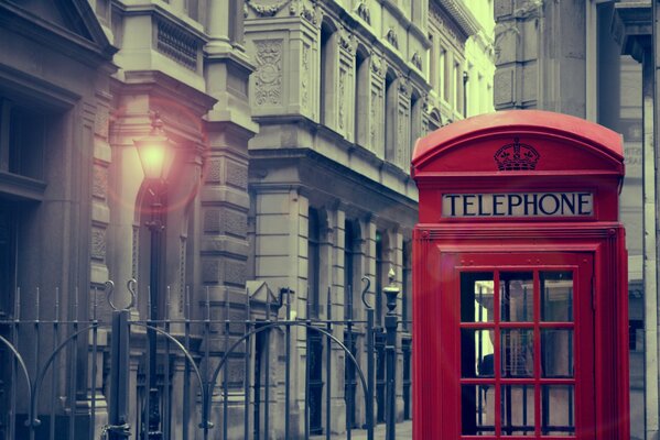 Cabina telefonica rossa a Londra su uno sfondo di edifici grigi