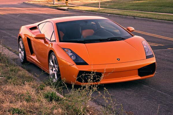 Lamborghini naranja a lo largo de la carretera vista frontal