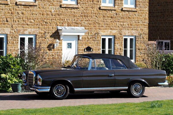 Mercedes Cabriolet se trouve près de la maison noire