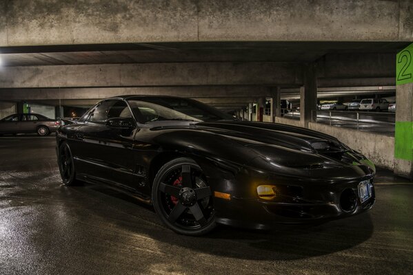 Black tinted pontiac in the parking lot