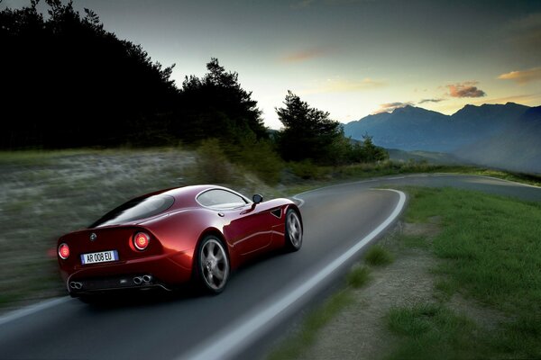 Alfa romeo 8C competizione rojo en las montañas a la velocidad