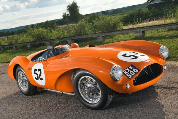 Arancione Aston Martin su una strada rurale