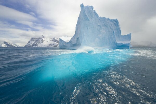 Frosty blue iceberg in the water