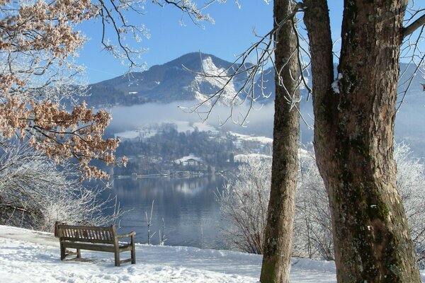 Bench in front of snow-capped mountains