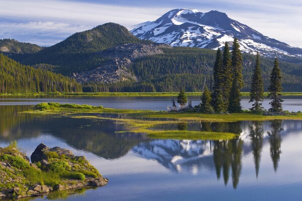 A wide lake in the mountains and a green forest