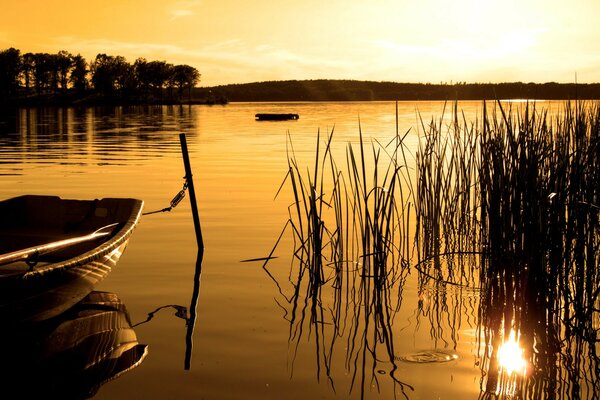 Boot in einem ruhigen See bei Sonnenuntergang