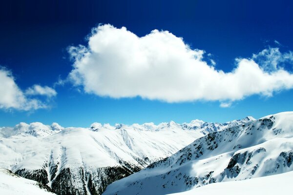 Eroberter schneebedeckter Gipfel in den Wolken