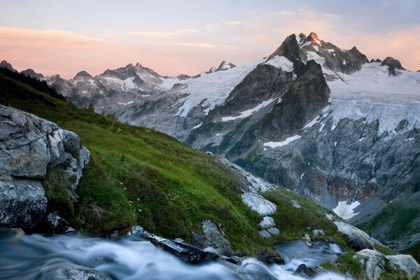 Die mit Gras bedeckten Berge sind mit Schnee bedeckt