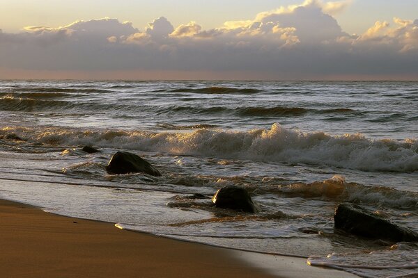 Spruzzi di onde nel surf colpiscono le rocce