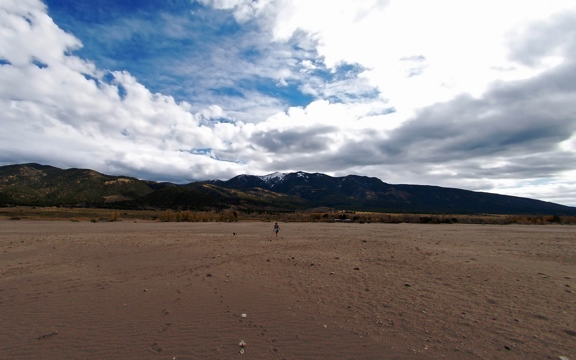 montagnes sable homme traces nuages