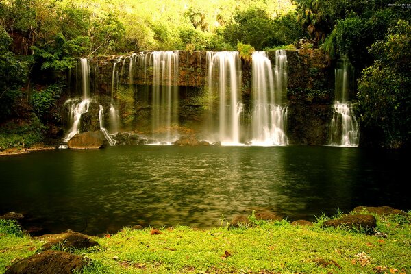 Saftige Sommerlandschaft mit Wasserfall und See