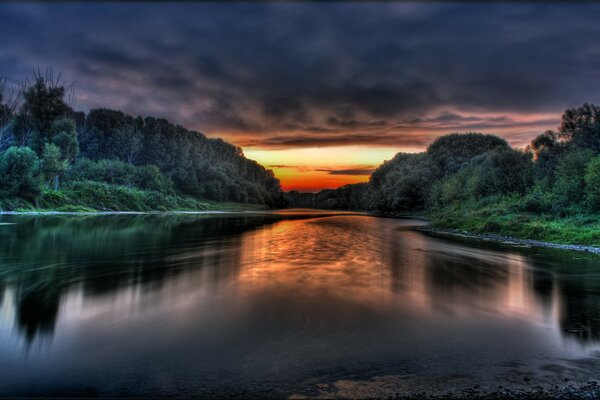 Nuvole sulle rive del fiume al tramonto