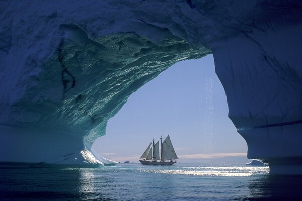 Velero cerca de un glaciar en el mar