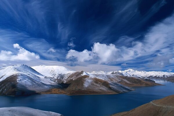 The river flows between snow-capped mountains