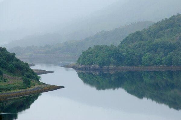 Las montañas de Escocia, la niebla se arrastra sobre la superficie del agua