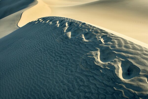 Paesaggio con deserto e impronte sulla sabbia