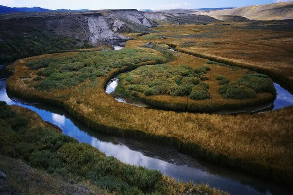 El cauce del río rodea las montañas y los campos