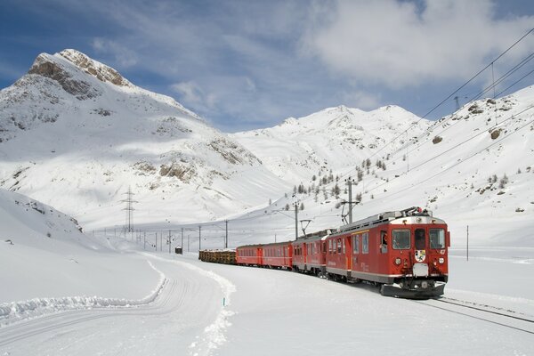 Tren rojo en invierno en las montañas