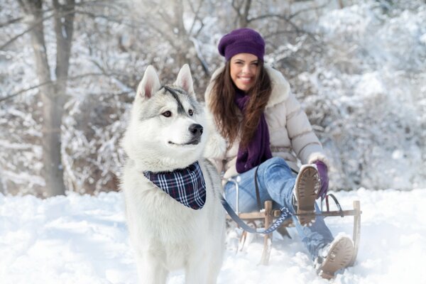 Fille avec un traîneau et un traîneau sur la neige